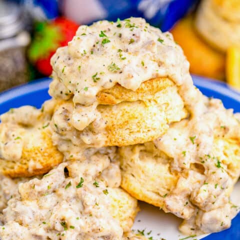 A stack of biscuits and gravy on a blue and white plate.