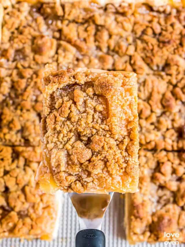 a slice of apple slab pie lifted up by a serving spatula