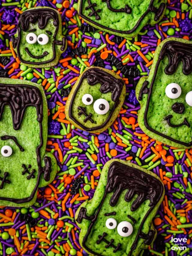 A bunch of halloween cookies on colorful sprinkles.