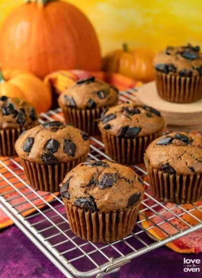 chocolate chip pumpkin muffins on a wire cooling rack.