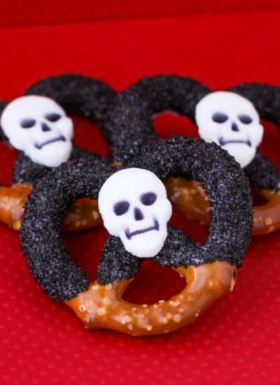 Halloween pretzels covered in chocolate and black sprinkles.
