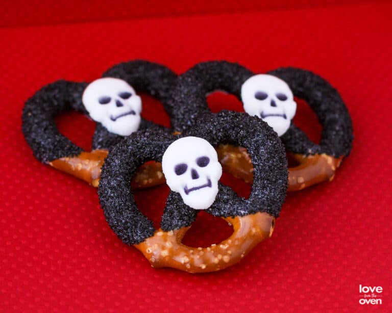 Halloween pretzels covered in chocolate and black sprinkles.