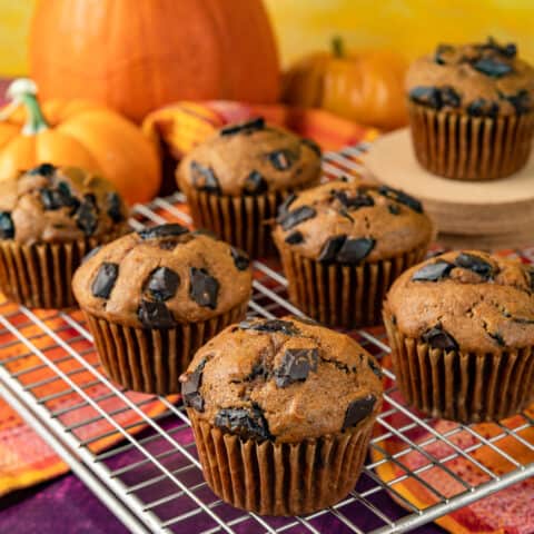 chocolate chip pumpkin muffins on a wire cooling rack.