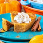 A slice of pumpkin pie on a blue plate.