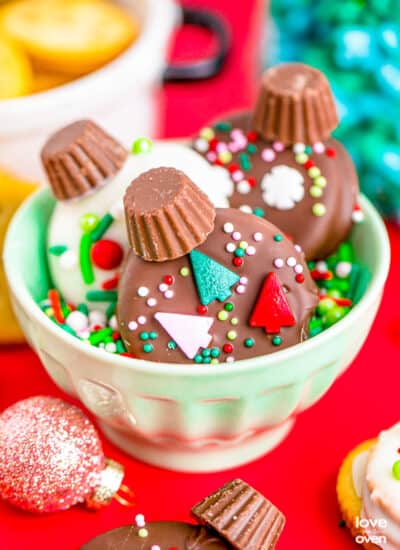 Chocolate covered ritz crackers decorated to look like ornaments, in a bowl.