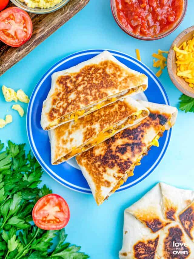 three halves of a breakfast crunchwrap on a blue plate