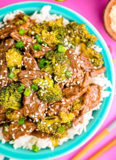 beef and broccoli on white rice in a turquoise bowl