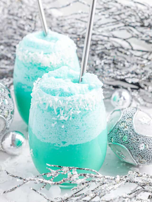Two blue jack frost cocktails with silver straws.