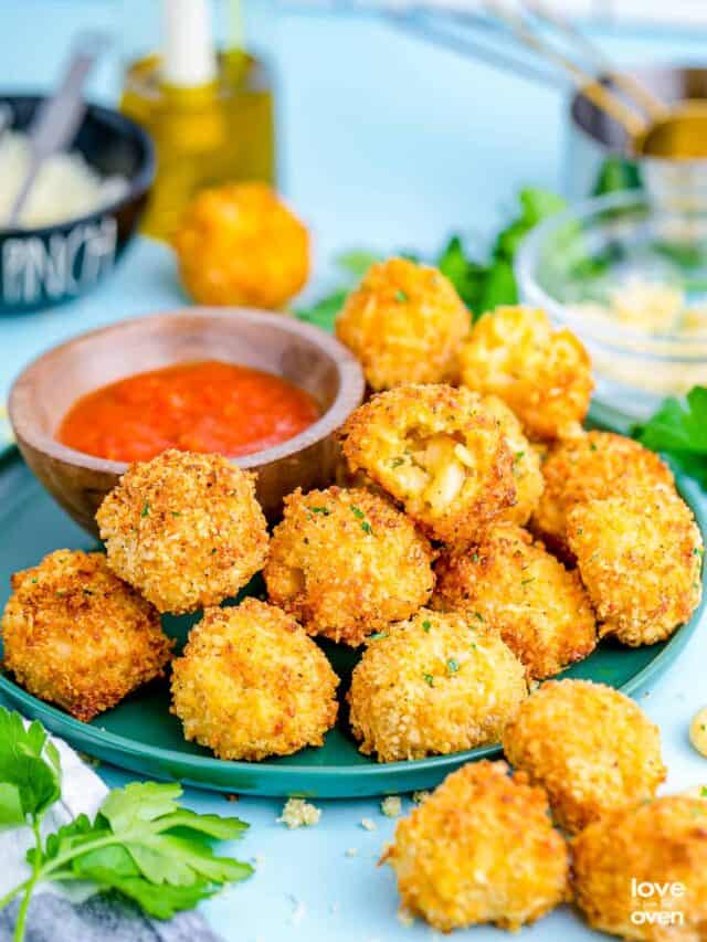 mac and cheese bites on a green plate with dipping sauce