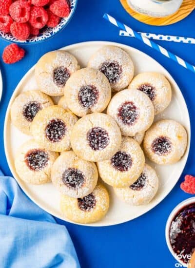 a plate of thumbprint cookies on a blue table