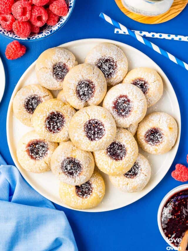a plate of thumbprint cookies on a blue table