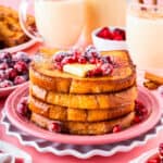 A stack of eggnog french toast on a pink plate.