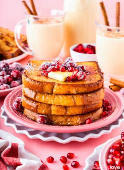 A stack of eggnog french toast on a pink plate.