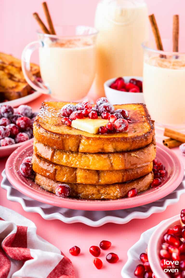 A stack of eggnog french toast on a pink plate.