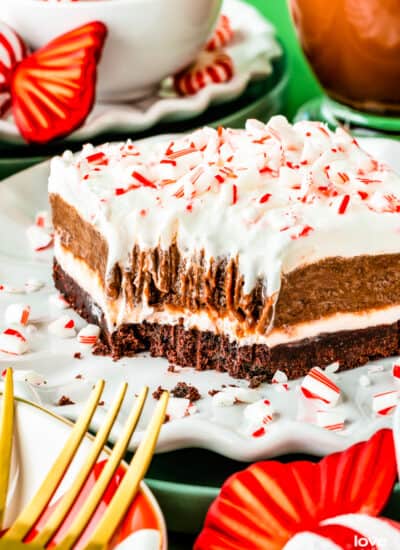 A slice of peppermint striped delight surrounded by Christmas decorations.