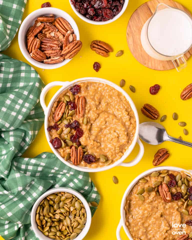 a bowl of pumpkin oatmeal with toppings on a yellow table