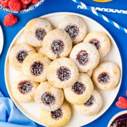 a plate of thumbprint cookies on a blue table