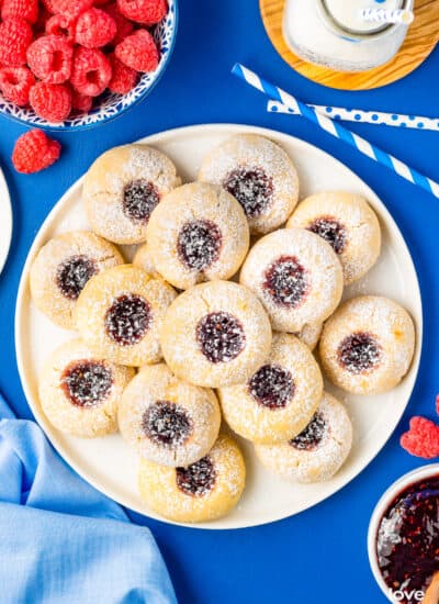 a plate of thumbprint cookies on a blue table