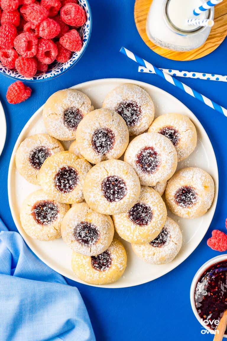a plate of thumbprint cookies on a blue table