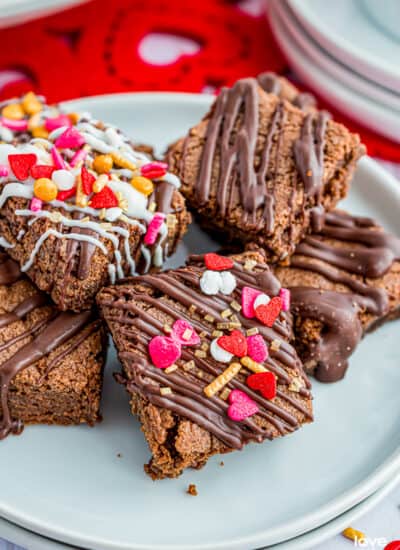 A plate of brownie bites with valentine sprinkles on them.