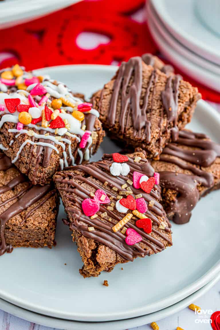 A plate of brownie bites with valentine sprinkles on them.