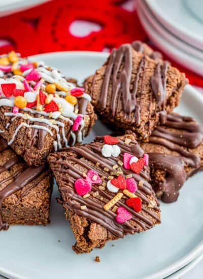 A plate of brownie bites with valentine sprinkles on them.