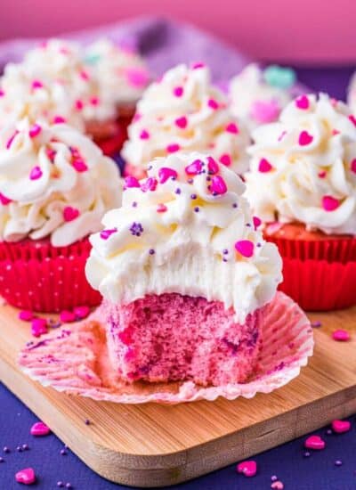 Pink velvet cupcakes on a purple and pink background.