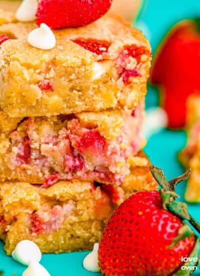 a stack of strawberry blondies next to some strawberries