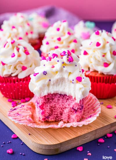 Pink velvet cupcakes on a purple and pink background.