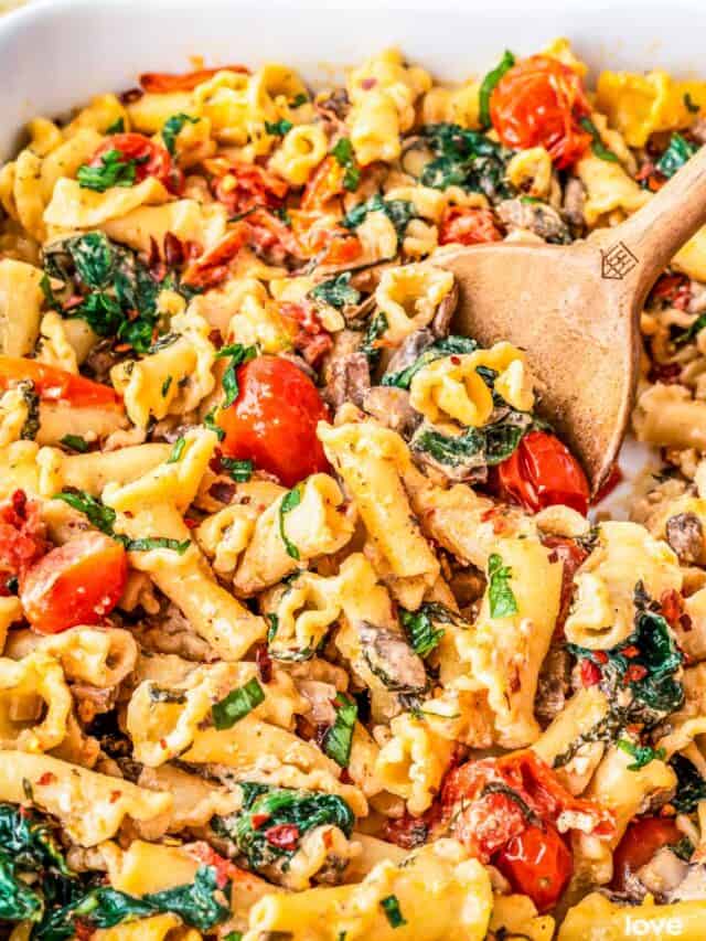 a wooden serving spoon scooping out some boursin cheese pasta