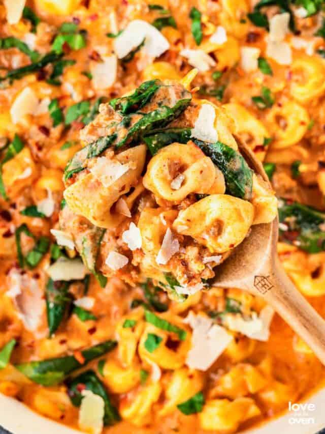 a serving spoon picking up some tortellini soup