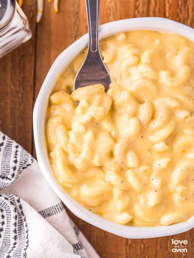 a fork in a bowl of macaroni and cheese