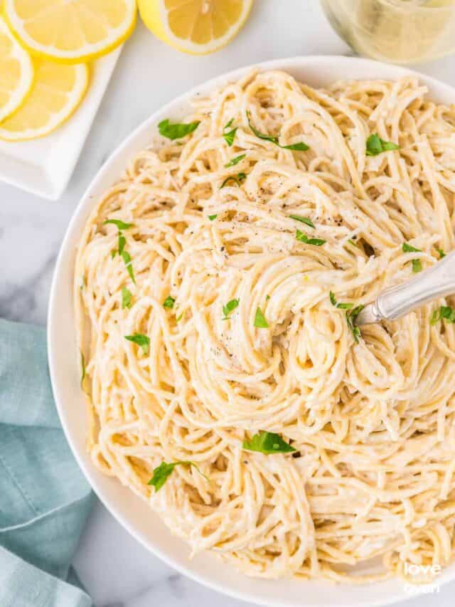 a fork digging into the center of some lemon butter pasta