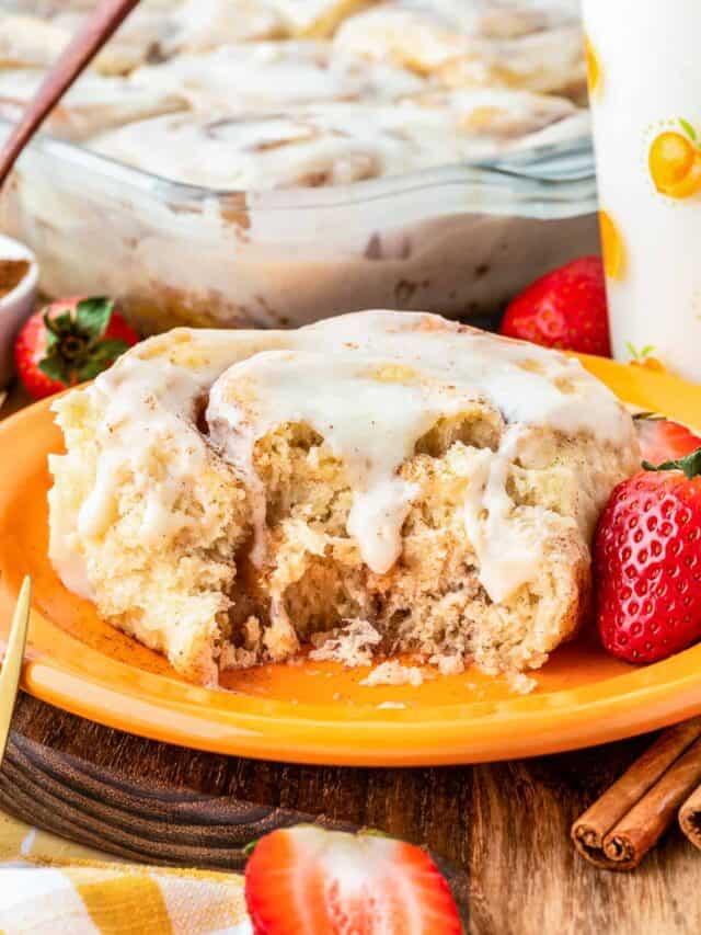 An overnight cinnamon roll on an orange plate