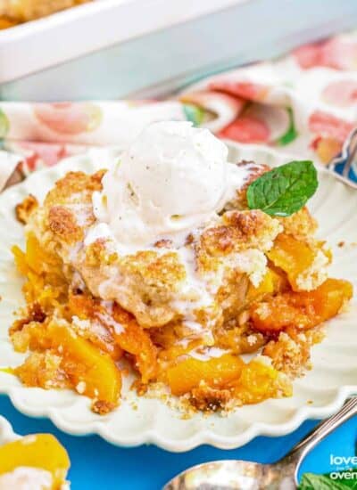 A plate with peach cobbler topped with ice cream