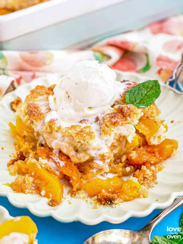 A plate with peach cobbler topped with ice cream