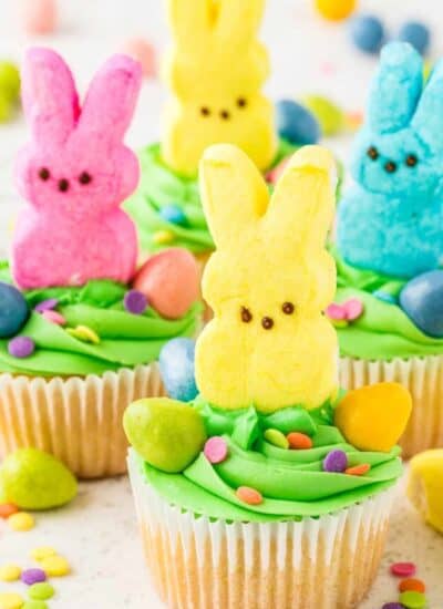 Cupcakes with green frosting and marshmallow bunny Peeps on top of them.