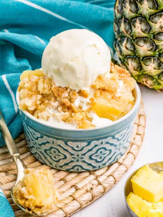 pineapple dump cake in a ramekin with a scoop of ice cream on top
