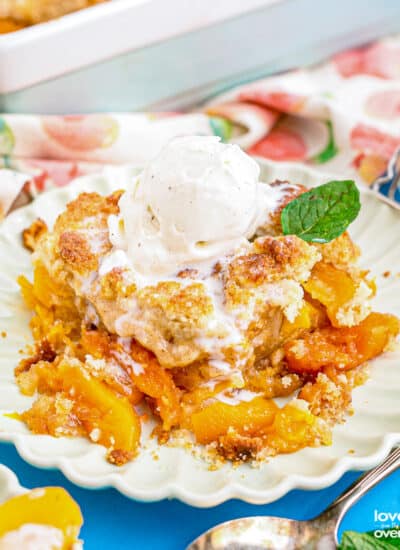 A plate with peach cobbler topped with ice cream