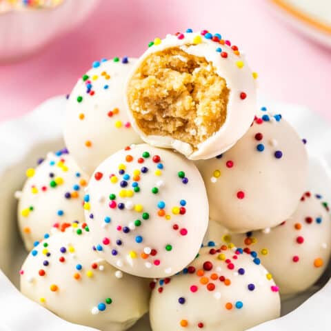 a stack oof sugar cookie truffles and the top one has a bite taken out of it