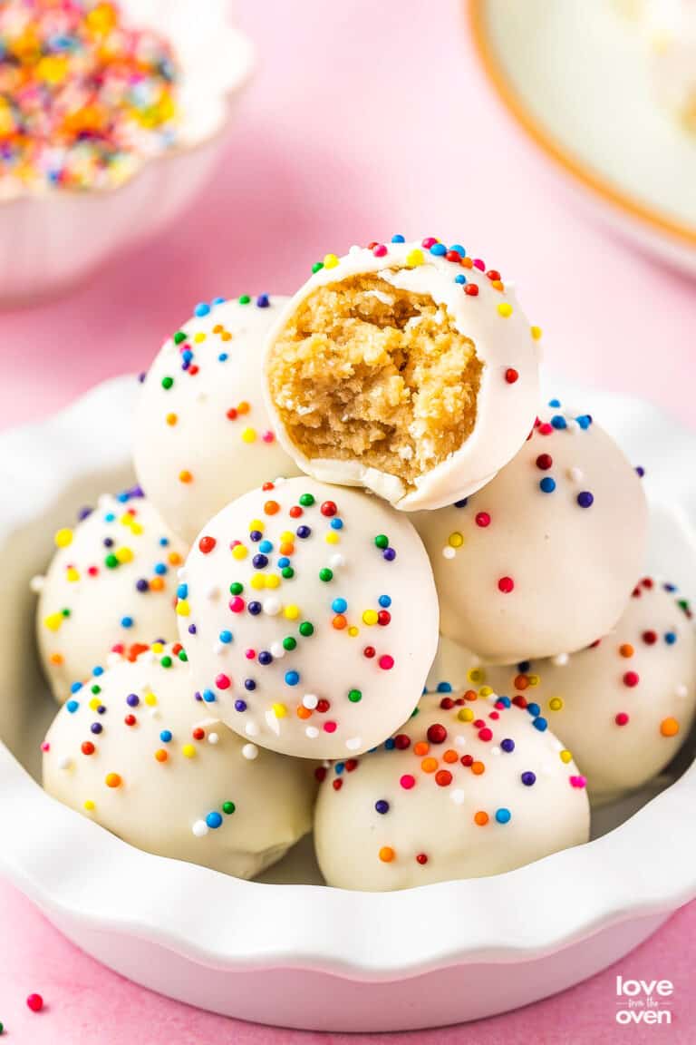 a stack oof sugar cookie truffles and the top one has a bite taken out of it