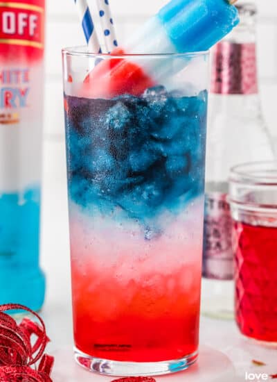 A red white and blue cocktail with a bomb pop on top