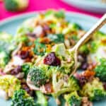 a spoon holding a spoonful of broccoli salad