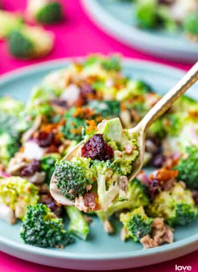 a spoon holding a spoonful of broccoli salad