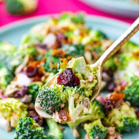 a spoon holding a spoonful of broccoli salad