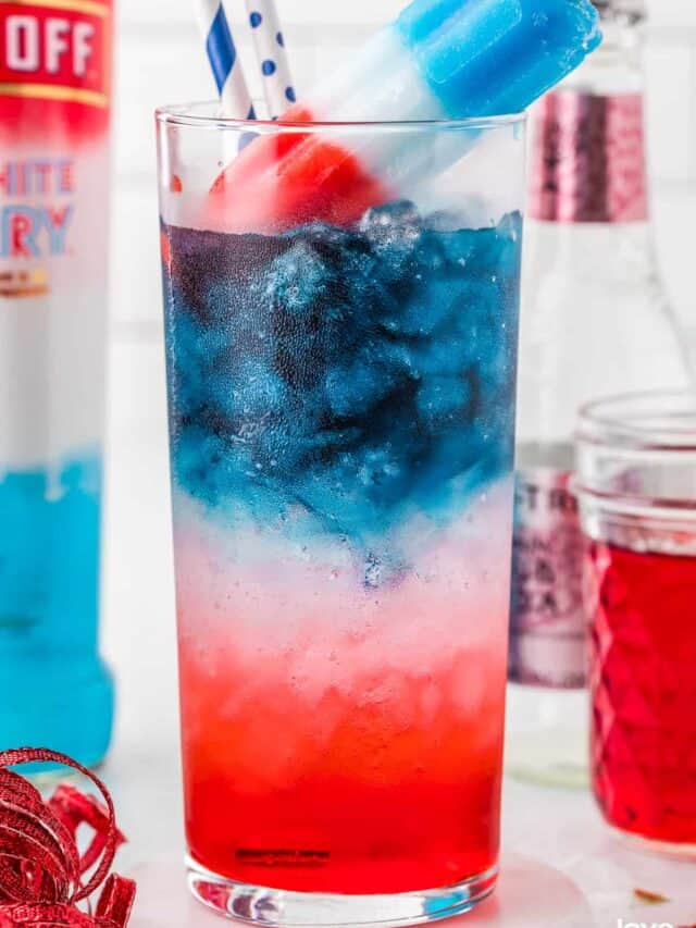 A red white and blue cocktail with a bomb pop on top