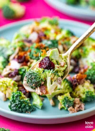 a spoon holding a spoonful of broccoli salad