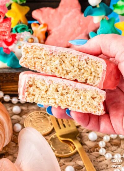 a hand holding a star shaped rice krispie treat that has been cut in half