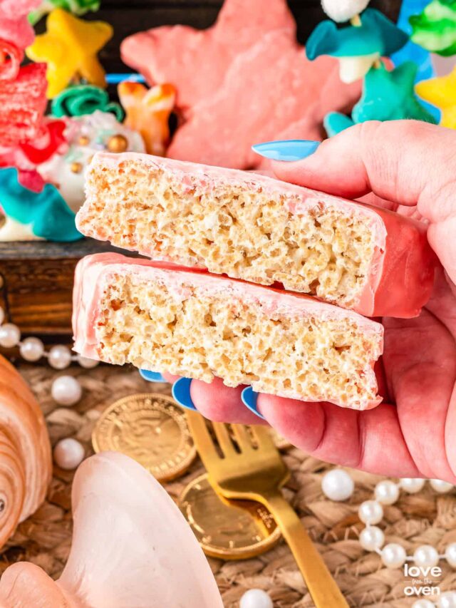 a hand holding a star shaped rice krispie treat that has been cut in half