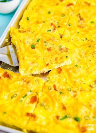 a close up of a spatula picking up some sheet pan eggs